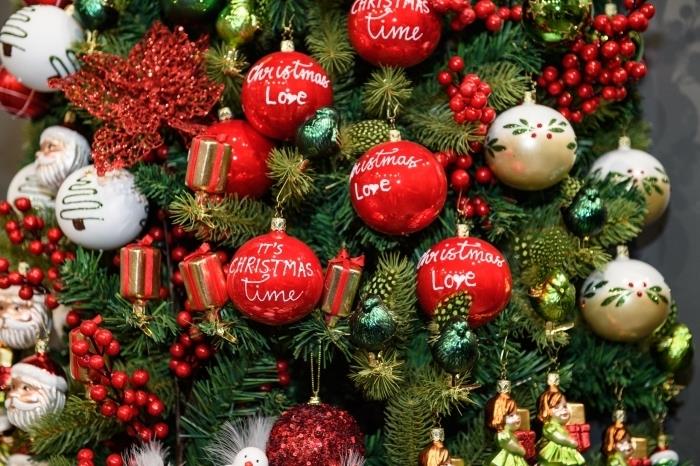 Noel Baba kafa tasarım figürleri ve Mutlu Noeller mesaj topları ile yeşil bir Noel ağacının nasıl süsleneceğine dair örnek