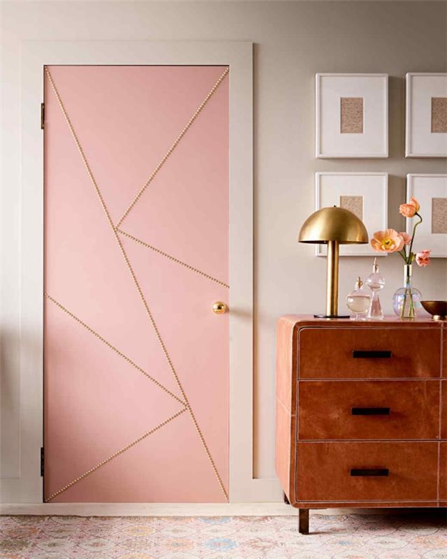 durų dekoravimo idėja rožinėje, šviesiai pilkoje sienoje, senovinė ruda komoda, rėmo deko