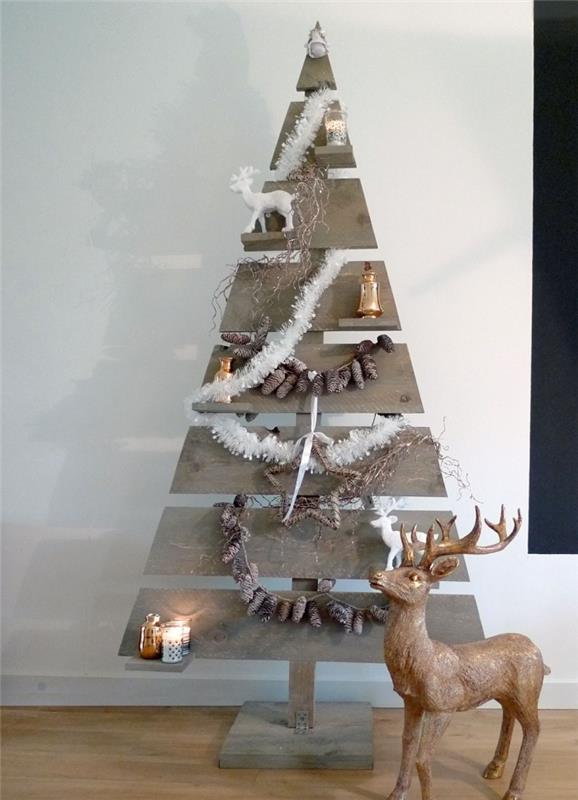 mumlar ve çam kozalağı çelenklerle süslenmiş geri dönüştürülmüş bir paletten yapılmış rustik görünümlü ahşap Noel ağacı