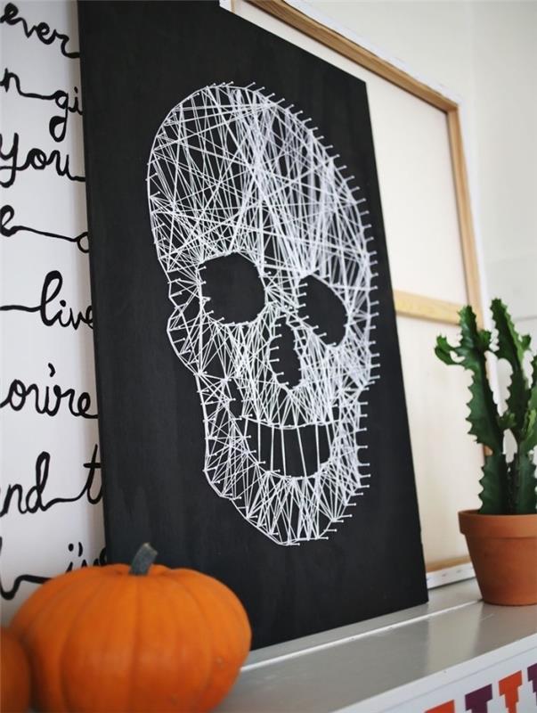 „pasidaryk pats“ Helovino dekoracijos pavyzdys su kaukolės formos lenta ir mažu oranžiniu moliūgu