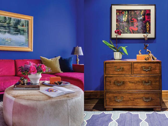 stensko poslikavo, dnevna soba s temno modro pobarvanimi stenami, žametna zofa v barvi maline, okvir za fotografije zlate barve