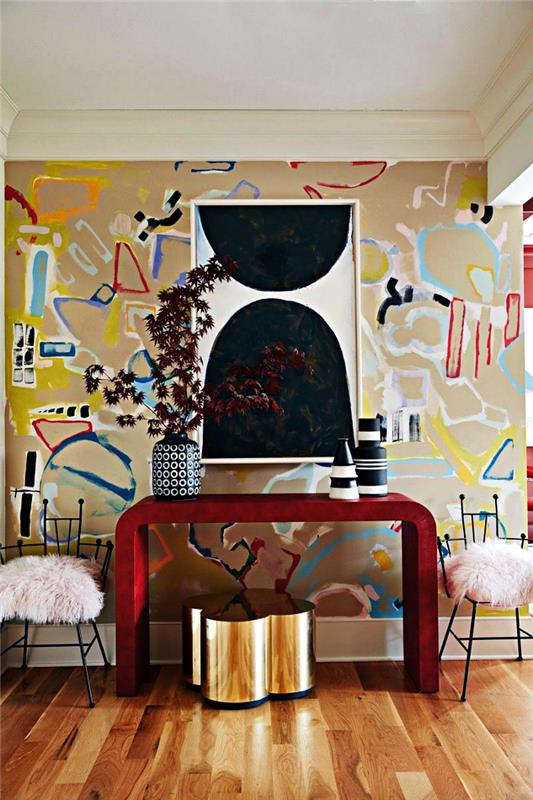 sodobna dekoracija doma, eleganten vhod z rdečo oblikovalsko konzolo, medeninastim stolčkom in steno z grafičnimi in barvitimi ozadji