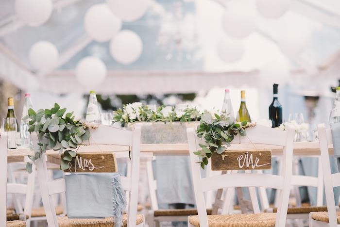 šalies dekoras jūsų vestuvėms, baltas gėlių stalas ir kėdės, papuoštos žalumynais, gėlių centras, balti balionai