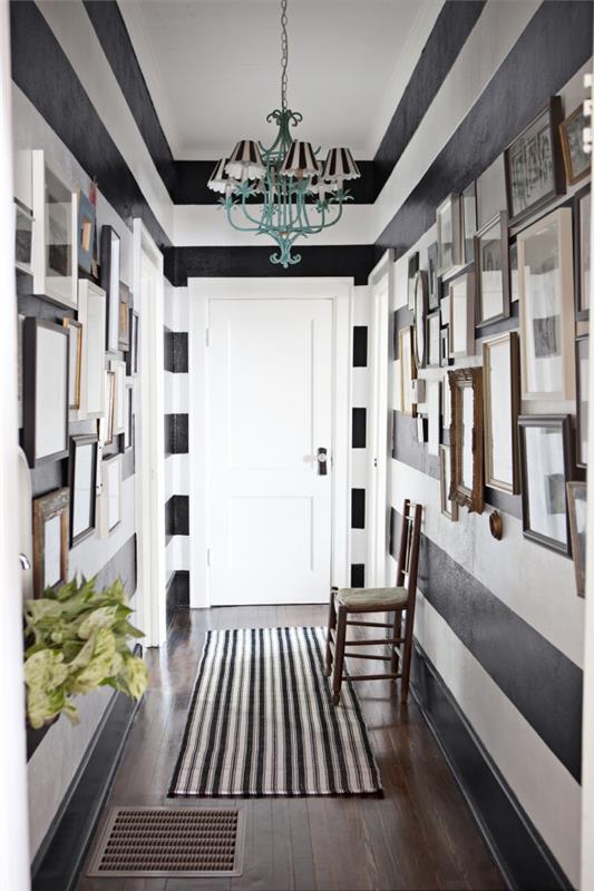 farklı boyut ve renklerde resim çerçevelerinin sanat dekorasyonu ile beyaz ve siyah çizgili koridor boyama