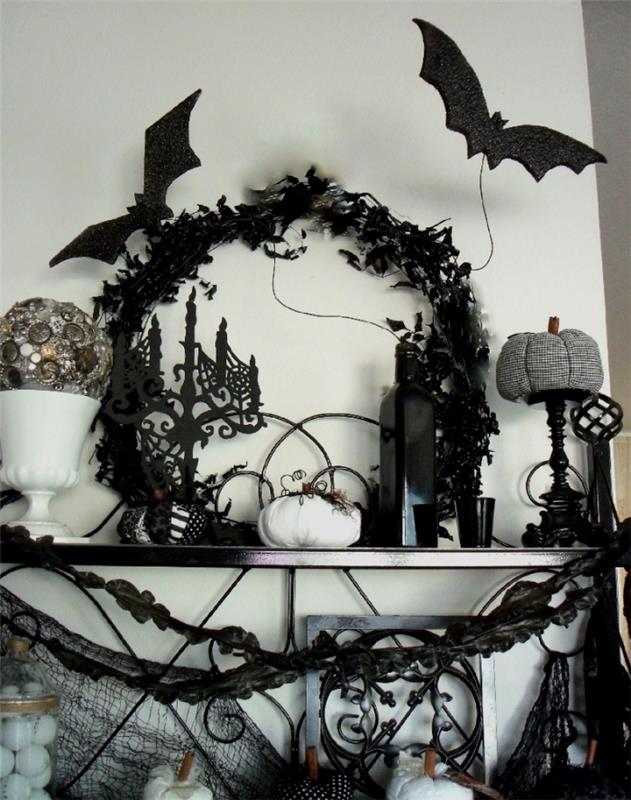 beyaz duvarlı oturma odası dekoru, siyah kuru yapraklarda çelenk, küçük beyaz balkabağı ve siyah kumaş