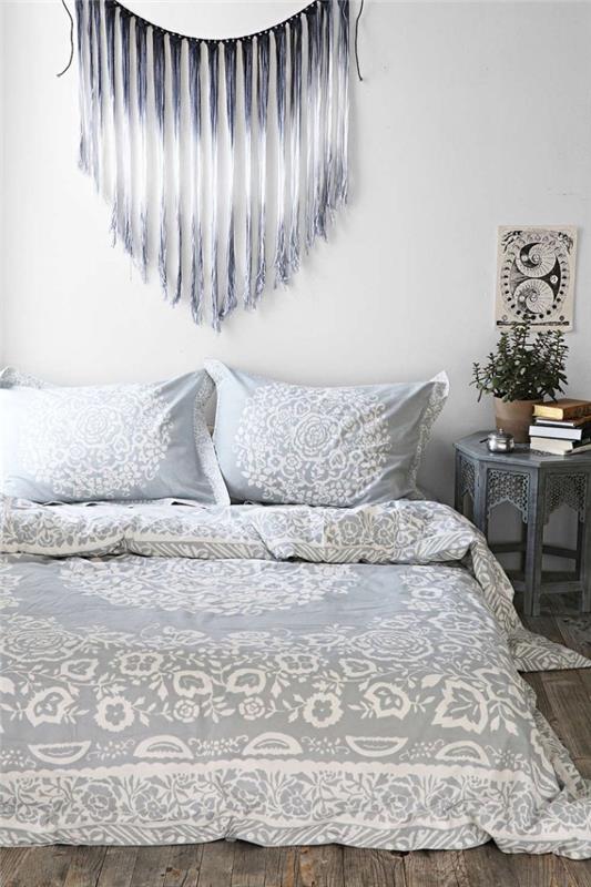 „Macrame“ pasidaryk pats raštas su tamsiai pilkos ir baltos spalvos dizainu, bohemiškas miegamojo dekoras su lova ant grindų ir baltos ir šviesiai pilkos spalvos patalyne su mandala