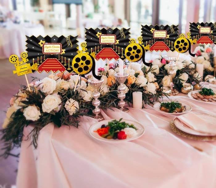 cinémá holivudo gimtadienio stalo apdaila, balta staltiesė, baltos rožės girlianda, kino deko motyvas
