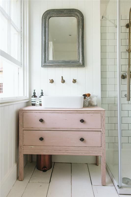 čudovit kotiček umivalnika vintage elegantnega duha z rožnato kopalniško omaro, opremljeno poleg tuš kabine