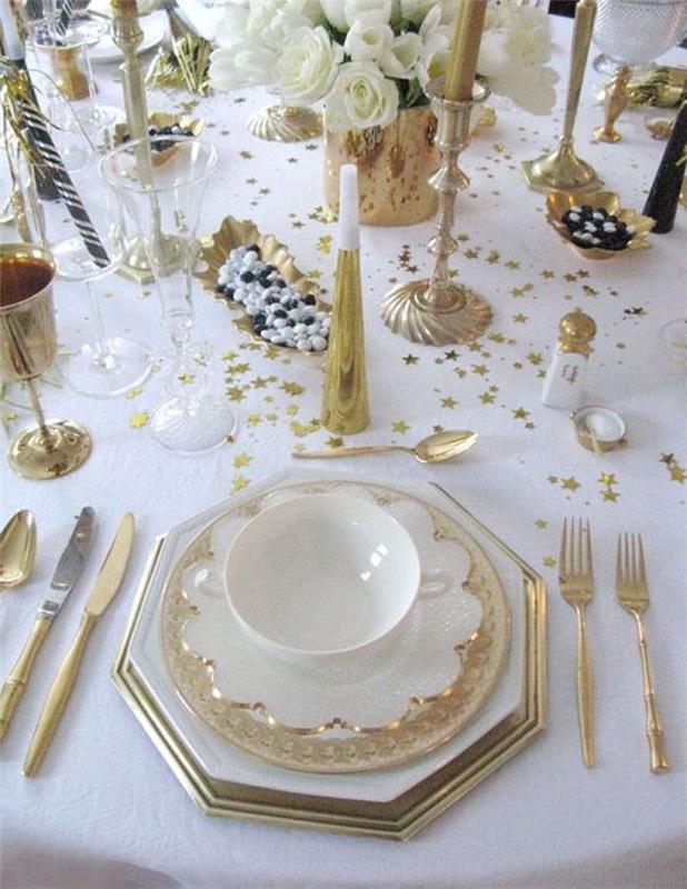 beyaz bir masa örtüsü üzerine serpilmiş altın konfeti kenarlıklı beyaz tabaklarla aziz arifesi masa dekorasyonu