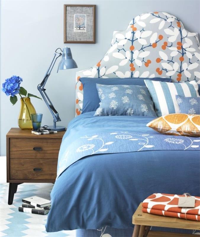 kako okrasiti svojo spalnico v modri, svetlo modri steni, modro -belem posteljnini, majhnih oranžnih poudarkih, leseni nočni omarici