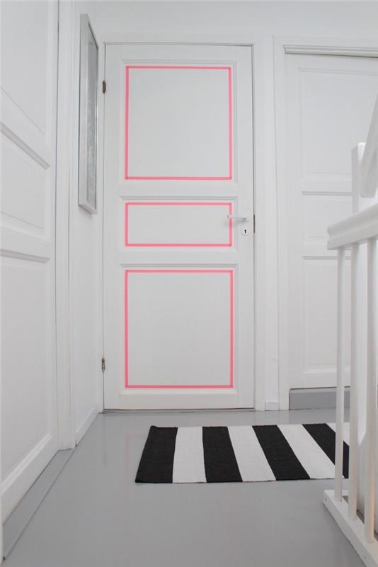 dekoratyvinė idėja, suteikianti energijos baltam nespalvotam įėjimui, durų liejimas, paryškintas rausvos maskavimo juostos juostele