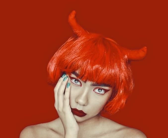 mat kırmızı ağızlı şeytan makyajı ve renkli göz kalemi ile vurgulanan bir görünüm, kaküllü ve şeytan boynuzlu başarılı şeytan kılığında kırmızı kare peruk