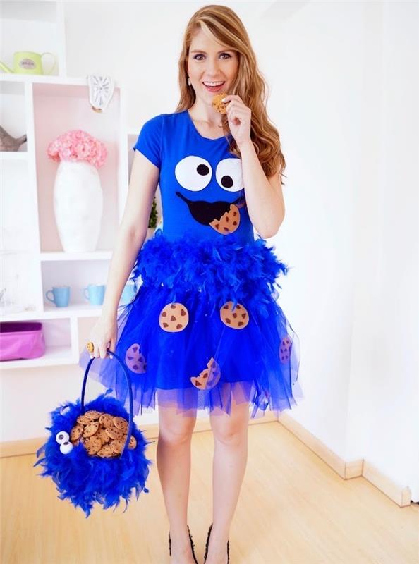 vaikiškas suaugusiųjų kostiumas, mėlynas „tutu“ sijonas, plunksnuota boa ir marškinėliai, mėlynas krepšelis, sausainių raštas, gurmaniškas makaronas