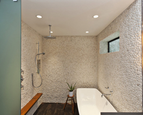 Pedras na parede do banheiro cobertas com tinta branca