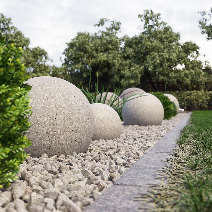 çakıl kaplı bir yüzey üzerinde bir bahçede dekoratif büyük yuvarlak taşlar
