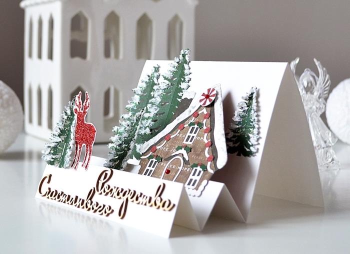 yapılacak bir Noel kartı örneği, kağıttan kesilmiş ev ve Noel ağaçları ile Noel peyzaj tasarımı ile DIY açılır kart şablonu