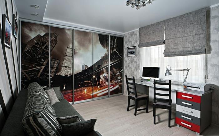 didelis plakatas pilkai baltame miegamajame, anglies pilka sofa, ilgas stalas, pramoninė stalinė lempa