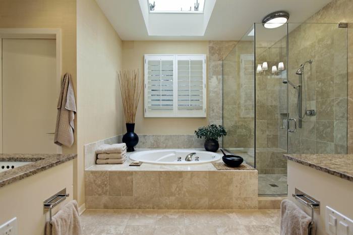 šviesiai smėlio spalvos vonios kambarys iš natūralios medžiagos su stoglangiu ir dušo zona
