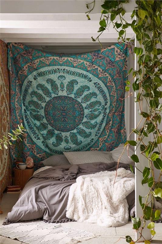 hipių prašmatnus arba bohemiško stiliaus miegamojo išdėstymas su etniniu gobelenu dekoruota siena ir lova ant grindų