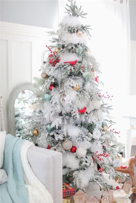 gri ve beyaz oturma odasında gümüş figürinler ve kırmızı kuş tasarım süsleri ile süslenmiş büyük Noel ağacı modeli