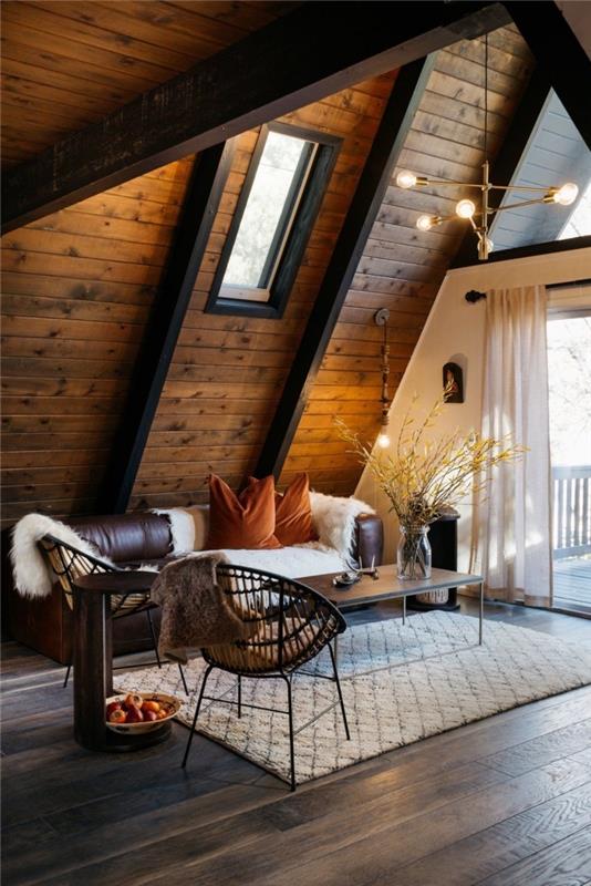deri koltuk mobilya ve metal masa ile koyu ahşap modern bir ahır, dağ evi tarzı dekorasyon örneği