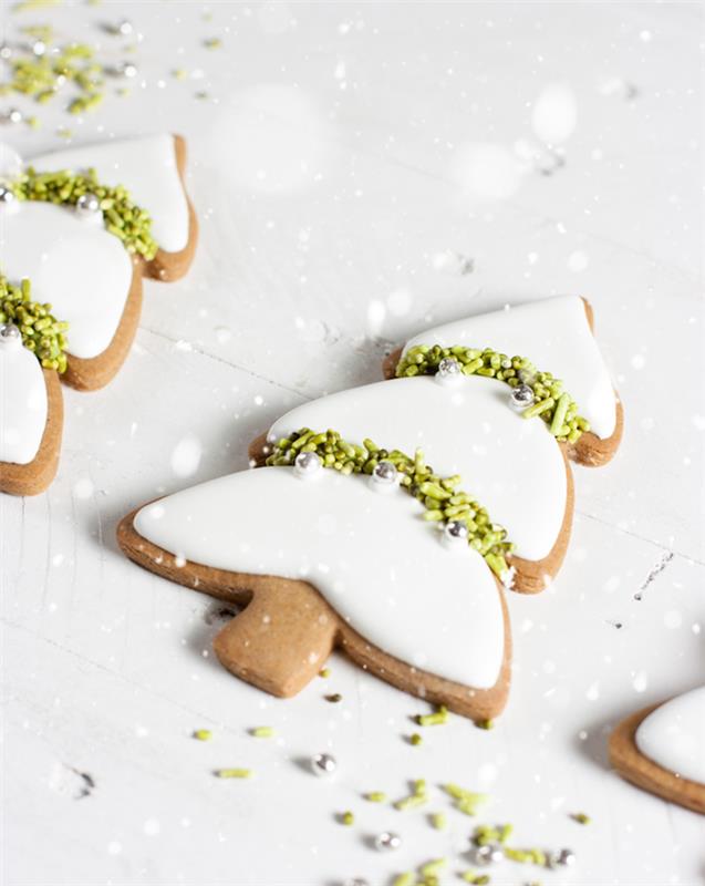 beyaz kraliyet kreması ve fıstık yeşili şeker serpme süslemeli bir Noel ağacı şeklinde zencefilli orijinal bir Noel kurabiyesi örneği