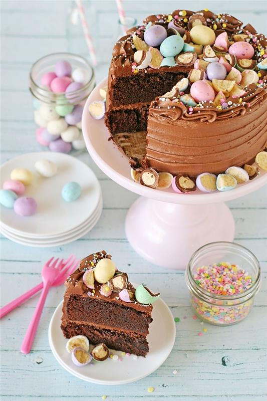 Enostavna čokoladna velikonočna torta s kakavovim biskvitom, napolnjena s čokoladno masleno kremo, okrašena s pastelnimi čokoladnimi jajci