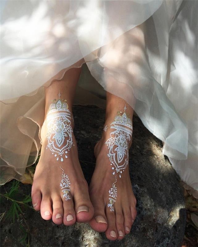bohemiškos tatuiruotės ant efektingų pėdų pavyzdys, chna tatuiruotės modelis baltos ir sidabrinės spalvos su etniniais motyvais