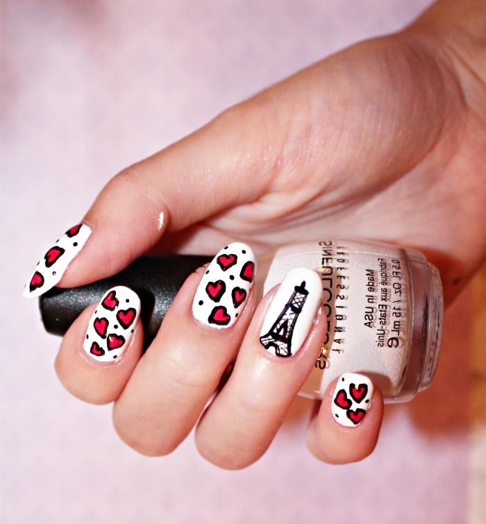 Paris design nail art s črno risbo Eifflovega stolpa na beli podlagi in majhnimi srčki v rdeči barvi