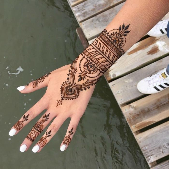 model ročne kane, manikura z belimi nohti, tetovaža črne kane z etničnim dizajnom za ženske