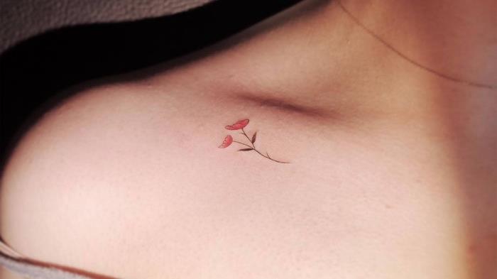 tetovaža z majhnimi rdečimi cvetovi na ključni kosti, minimalistična risba na telesu