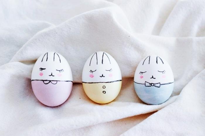 Velykų zuikio dizainas dekoruotas kiaušinių modeliais, dviejų spalvų baltais lukštais, kurių veidai nupiešti juodu žymekliu