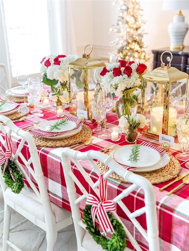 kırmızı ve beyaz bir masa için bir merkez parçası olarak kırmızı ve beyaz gül buketleri, biberiye markası, altın mum fenerler, orijinal Noel dekorasyon fikri