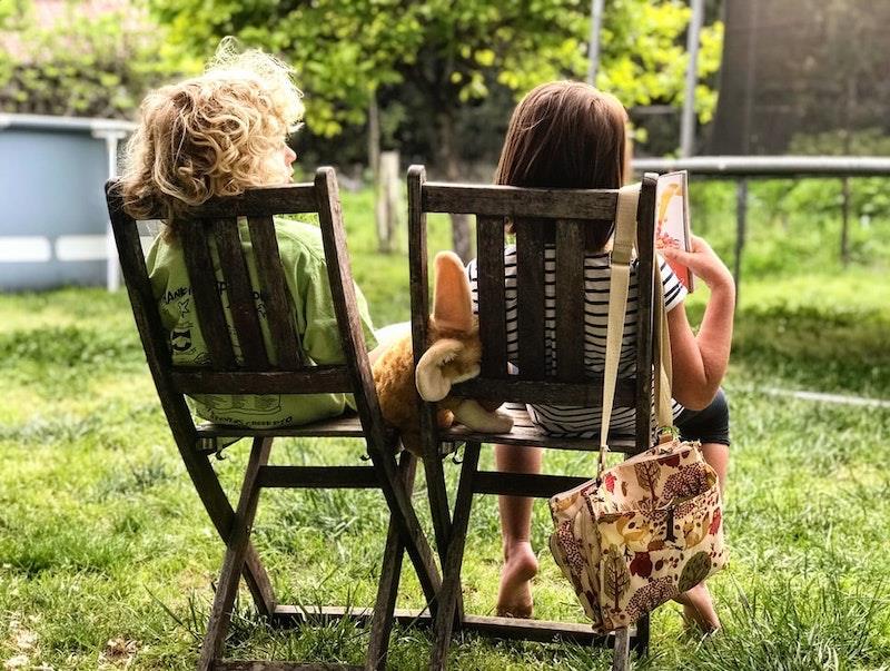 bahçede iki sandalyede oturan iki çocuk
