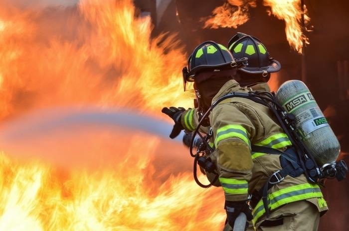 gasilci v ognju, ognjevarne uniforme z reflektorji, delovna oblačila