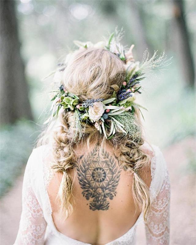 Orta boy saçlar için düğün saç modeli, modaya uygun bohem şık saç stilinde güzel kadın saçı, sırtı açık gelinlik, sırtta dövmeli kadın, iki darmadağınık örgüde kır çiçeği tacı
