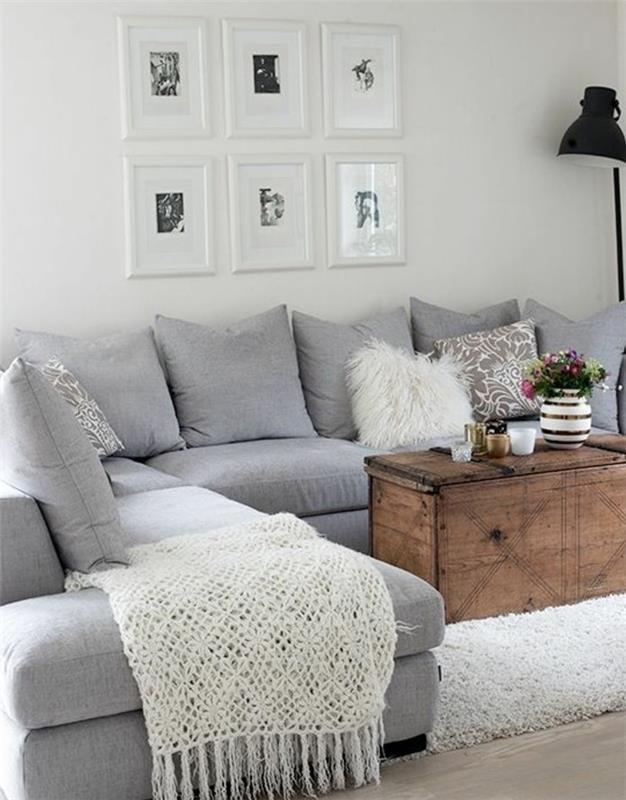 Idee arredamento soggiorno. divano angolare di colore grigio, tavolino di legno