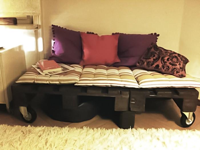 Idea arredamento con un bancale di legno utilizzato come divano, cuscini colorati come schienale