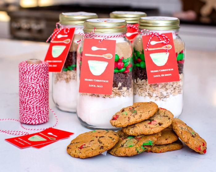 mason kavanozlarda yapısız kurabiyeler, ev yapımı yılbaşı hediyeleri, ön tarafta pişmiş kurabiyeler, kırmızı ve beyaz kurdele dekorasyonu
