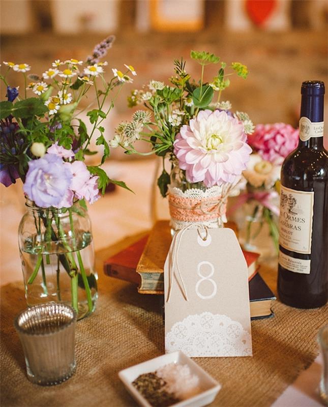 dekoracija poročne mize, tekač za mizo iz jute, vintage knjige, stekleni kozarci, preoblikovani v cvetlične lončke