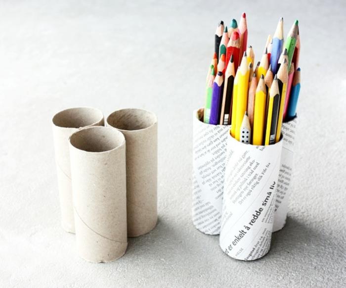 „pasidaryk pats“ ritininis tualetinis popierius, įvyniotas į laikraštį-idėja, kad būtų galima padaryti pieštuko laikiklį spalvotiems pieštukams