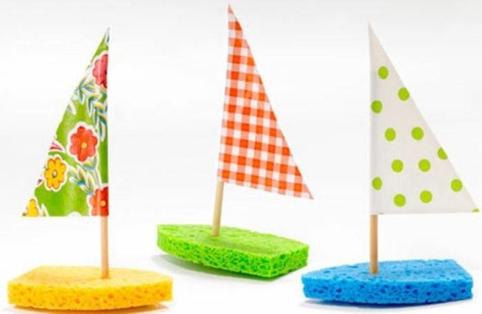zabavni umetniški projekti, trije čolni iz gob v rumeni, zeleni in modri barvi, okrašeni s trikotnimi jadri iz pisanega krep papirja