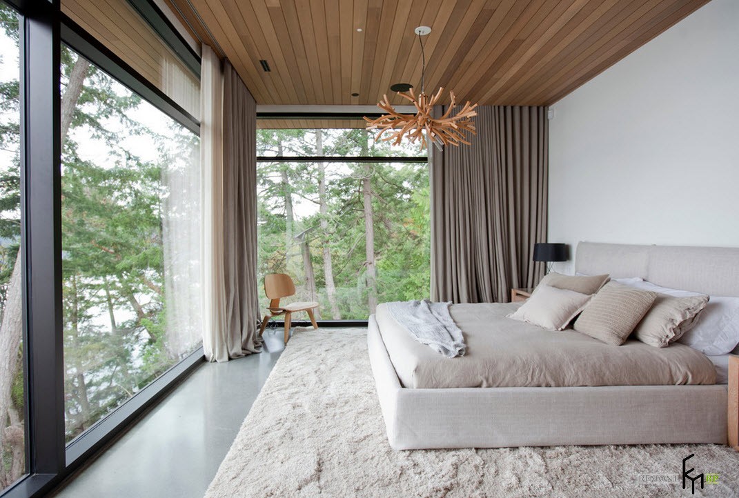 Yatak odasında ve ahşap tavanda panoramik pencereler