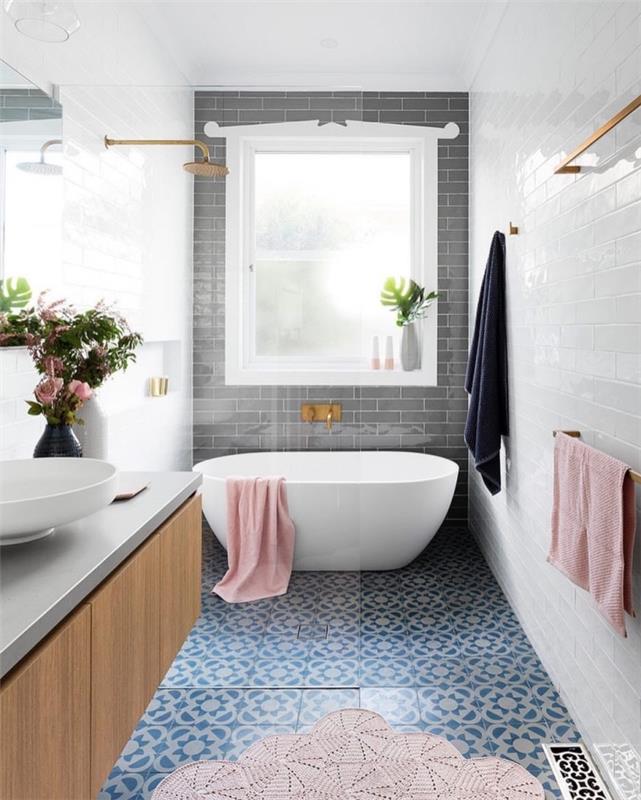 šio modernaus vonios kambario mėlynos spalvos marmurinių raštų cemento plytelių plytelės yra suporuotos su baltomis ir pilkomis metro plytelėmis