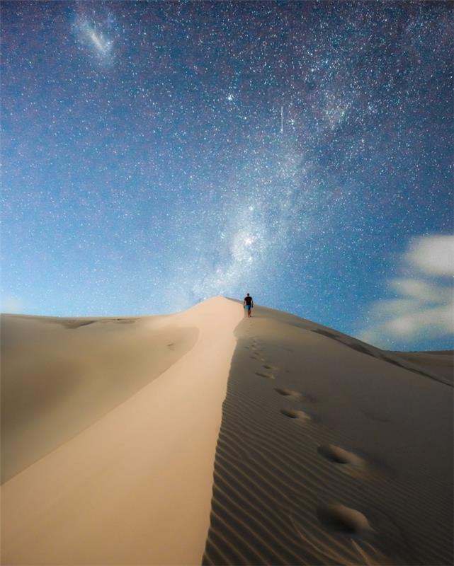 mobiliojo telefono tapetų vaizdas, kelionės nuotrauka su vyru, vaikščiojančiu dykumoje po žvaigždėtu dangumi