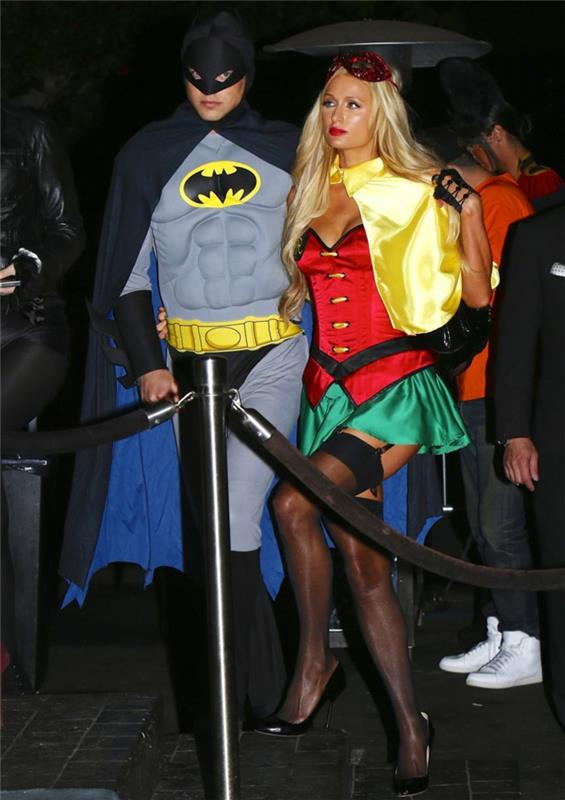 Paris Hilton apsirengusi kaip moteriška moteris, Betmenas, pora spalvingais drabužiais, originalūs Helovino kostiumai