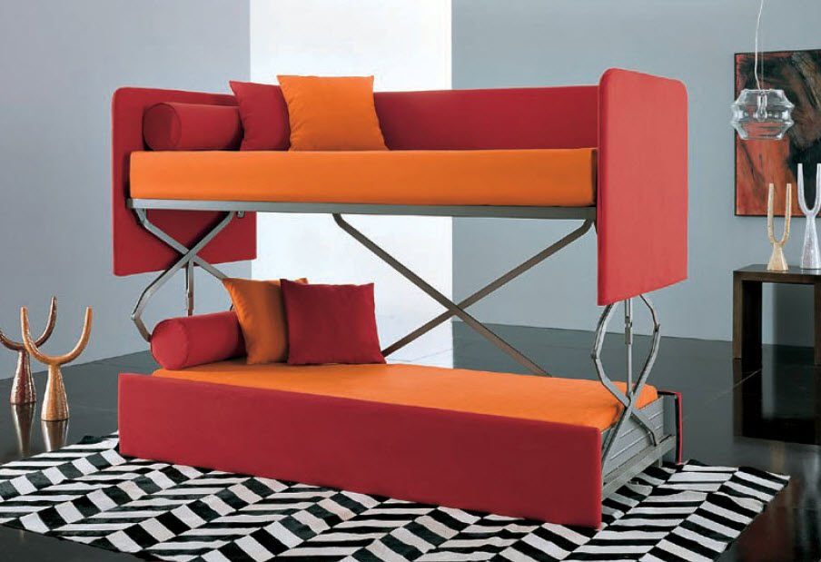 krasna-rdeča-in-oranžna-kavč-ki se-spremeni-v-posteljo-design-z-blazinami-na-chevron-z vzorcem-območje-preproga-v-sivi sobi