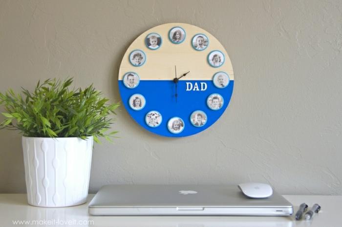 dyi ideje za darila, okrogla rumena in modra stenska ura z družinskimi fotografijami, obešena na svetlo kremni steni, v bližini lončnice, prenosnega računalnika, miške in dveh peresa