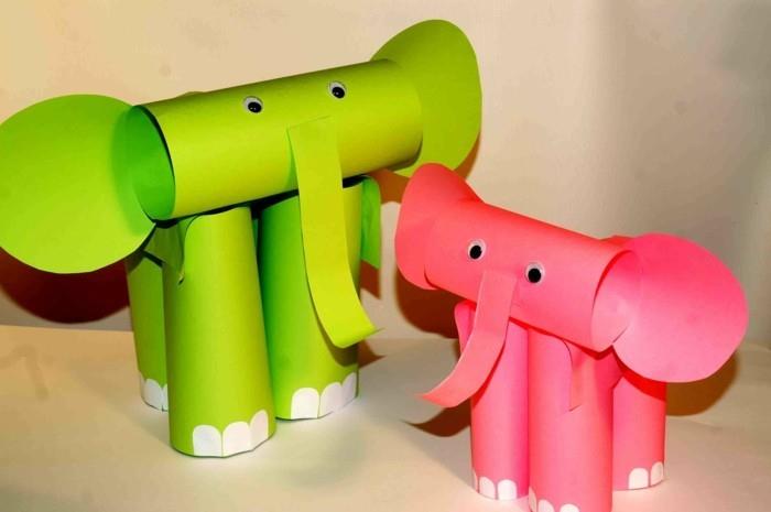 dva slona iz zelenega in roza papirja, zložena v valje, okrašena z belimi papirnatimi detajli in lepljivimi očmi