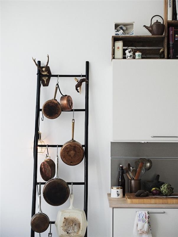 okrasne črne kovinske lestve za kuhinjo, kuhinjske pripomočke, lesena delovna plošča, bela kuhinjska sprednja stran